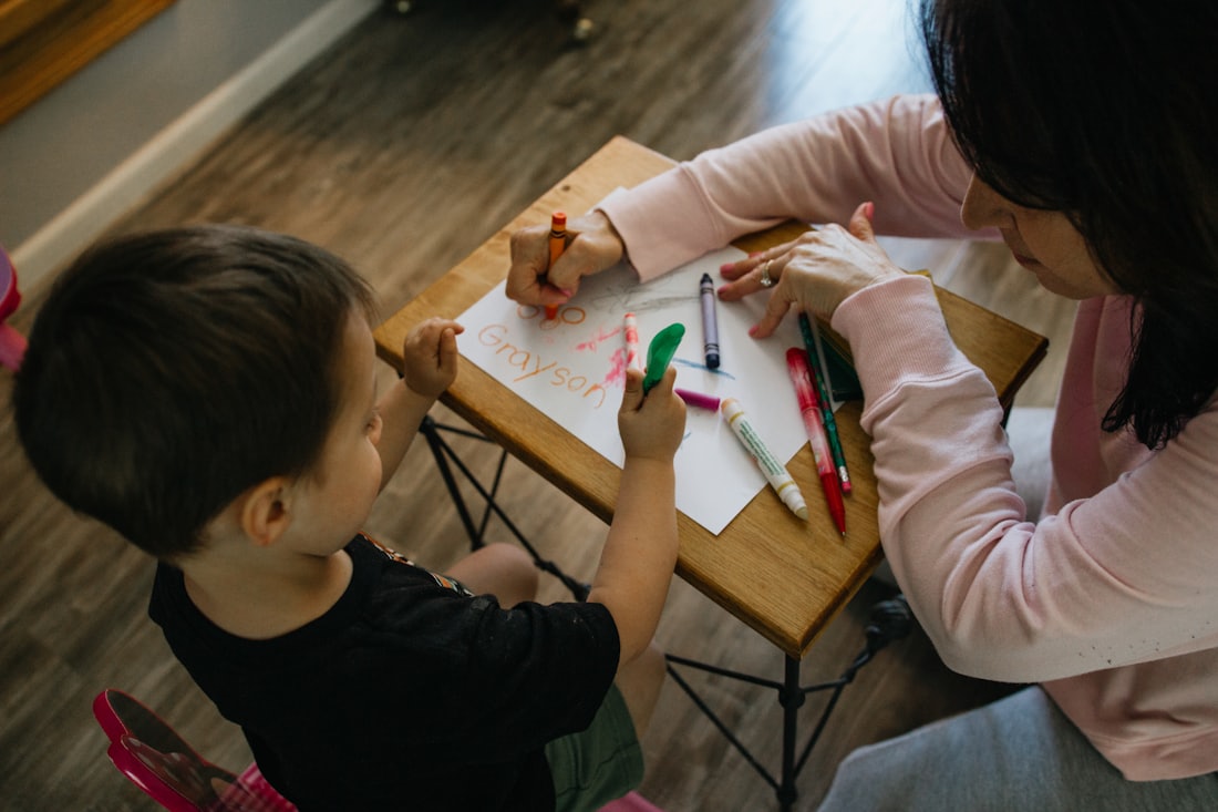 A parent and child working together at a small table
